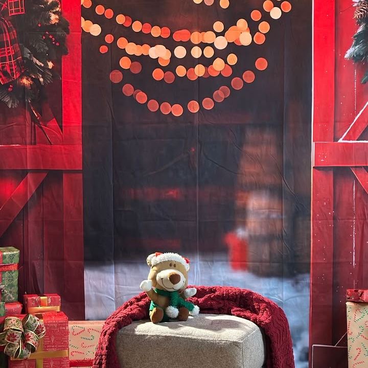 Fondo navideño de granero rojo con luces y banco con peluche