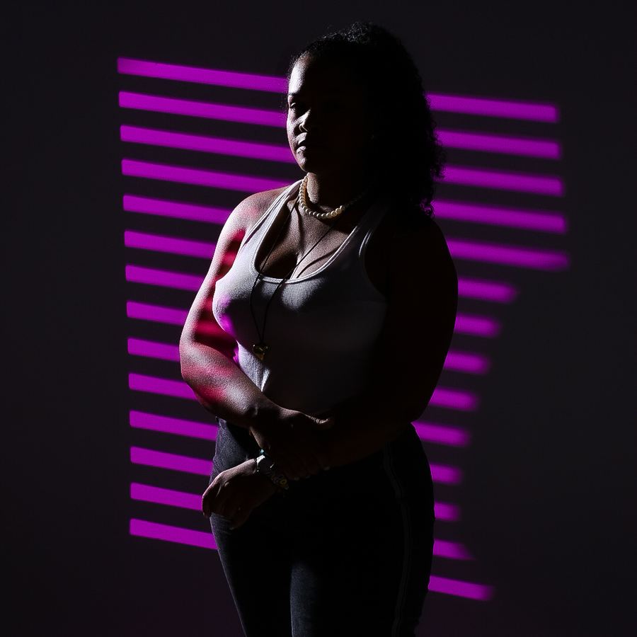 Retrato creativo con luces RGB magenta en el ciclorama